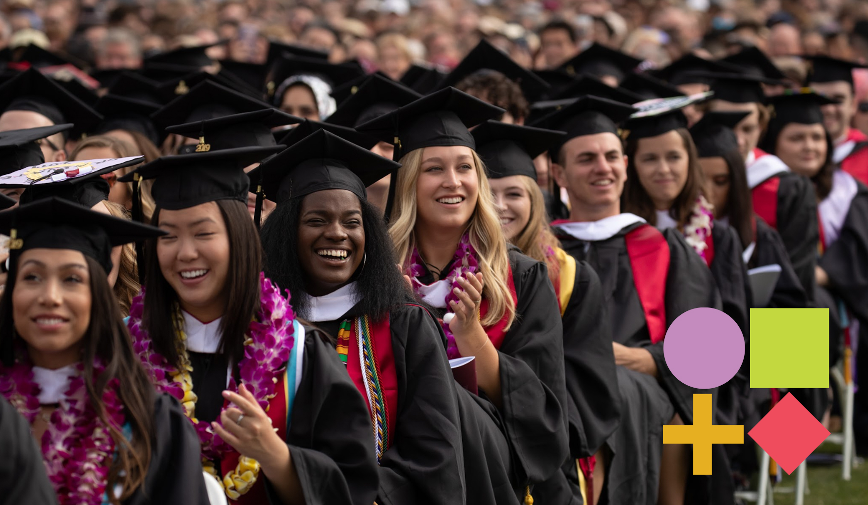 Graduates in caps and gowns with leis and stoles cheer at a commencement, signifying a celebration of diverse academic achievements.