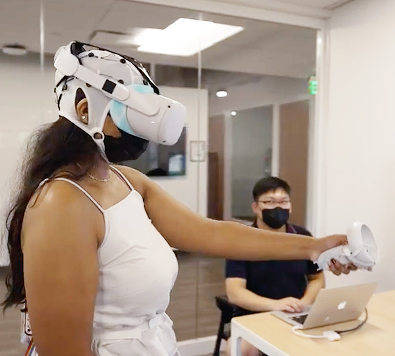 A female student wearing a VR headset, in a virtual reality training simulation